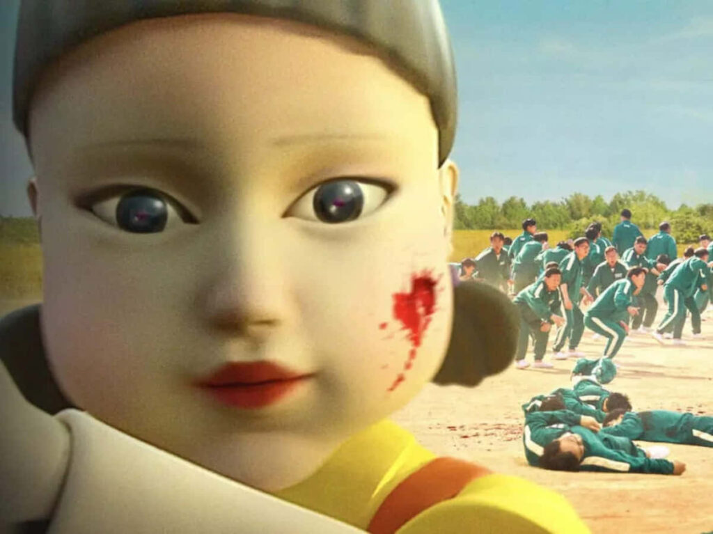 The Menacing Squid Game Doll: Bloody Face amidst Fallen Competitors Wallpaper