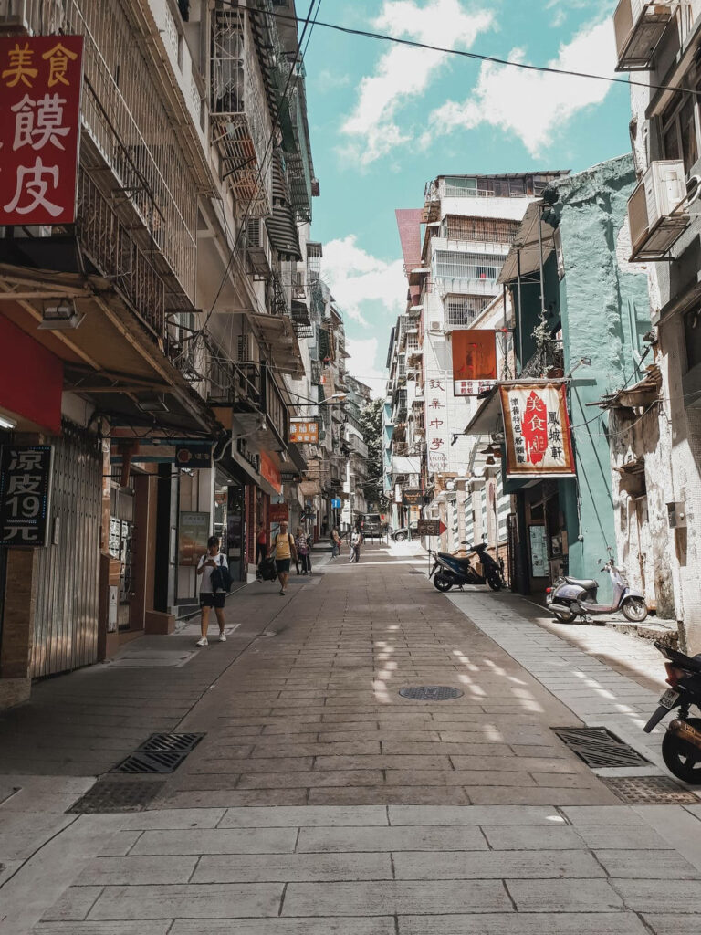 Chinatown narrow street with traditional buildings colorful signs scooters bright blue sky wallpaper