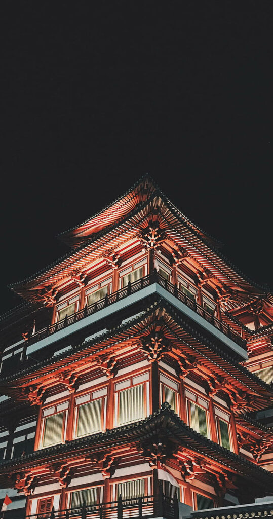 Chinatown temple at night with illuminated tiered roofs red and gold traditional architecture Wallpaper
