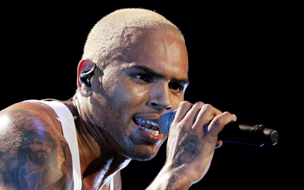 Chris Brown close-up performing on stage showing energetic expression and detailed tattoos wallpaper