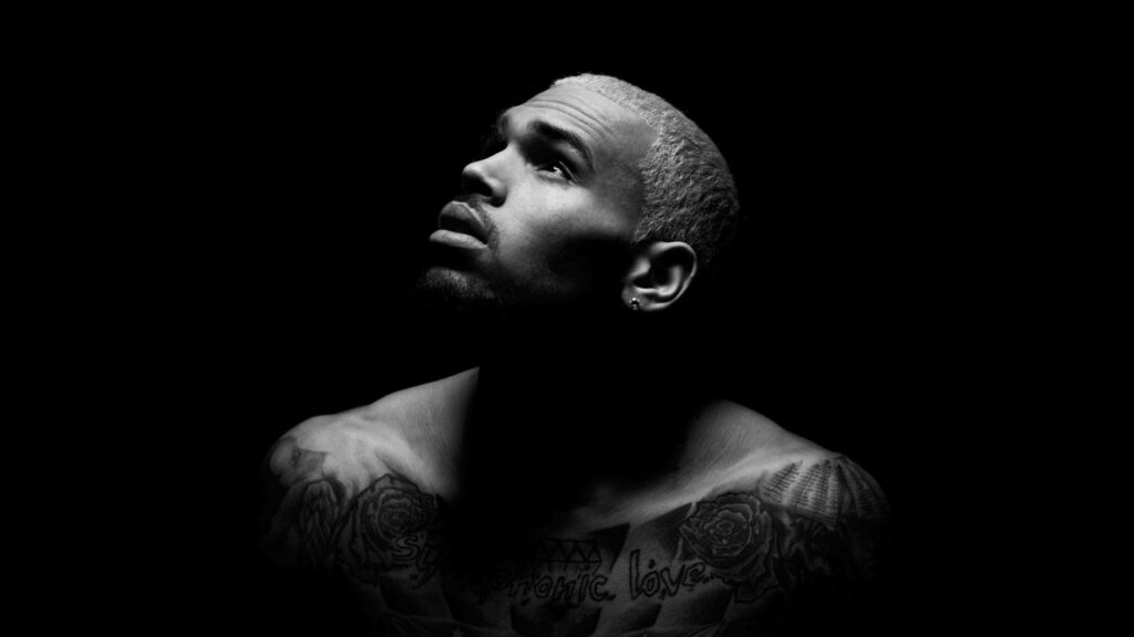 Grayscale Chris Brown wallpaper with dramatic lighting highlighting his tattoos and face