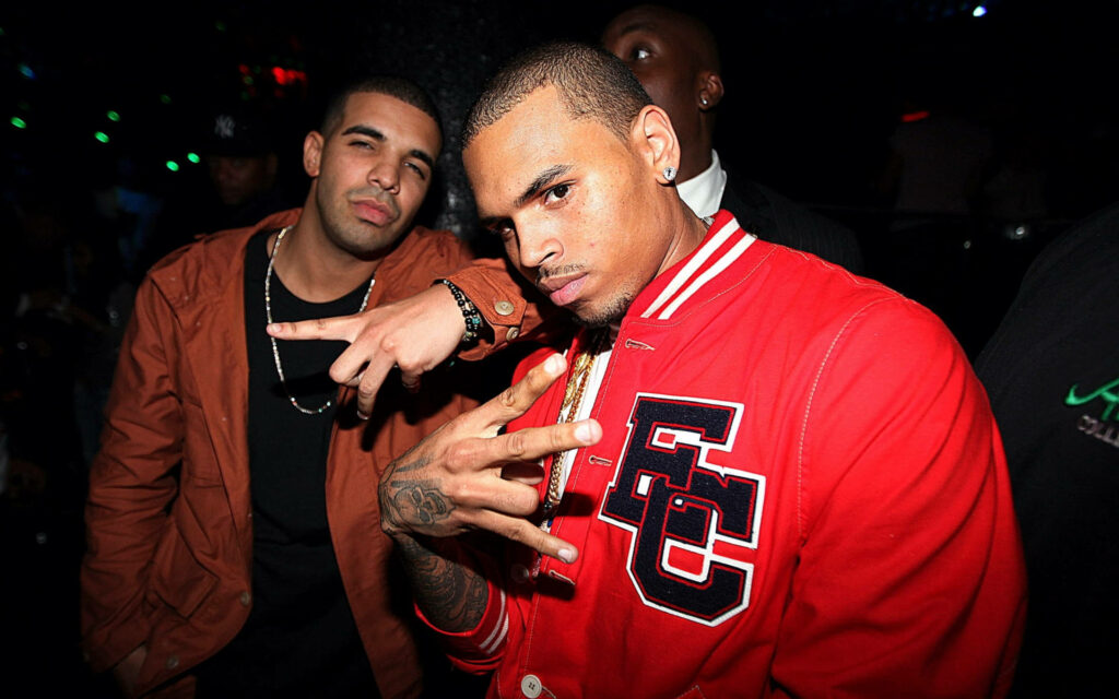 Chris Brown and Drake in vibrant club with colorful lights confident relaxed hand gestures Wallpaper