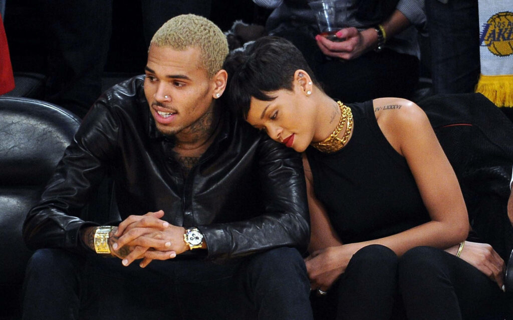 Chris Brown and Rihanna sitting closely together intimate candid moment with wallpaper background