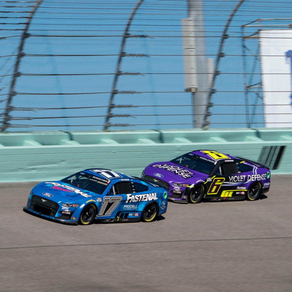 Chris Buescher Fastenal NASCAR car racing closely with competitor showcasing high speed action Wallpaper