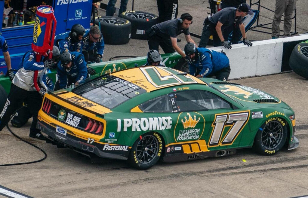 Chris Buescher number 17 race car in fast pit stop with crew servicing on racetrack wallpaper
