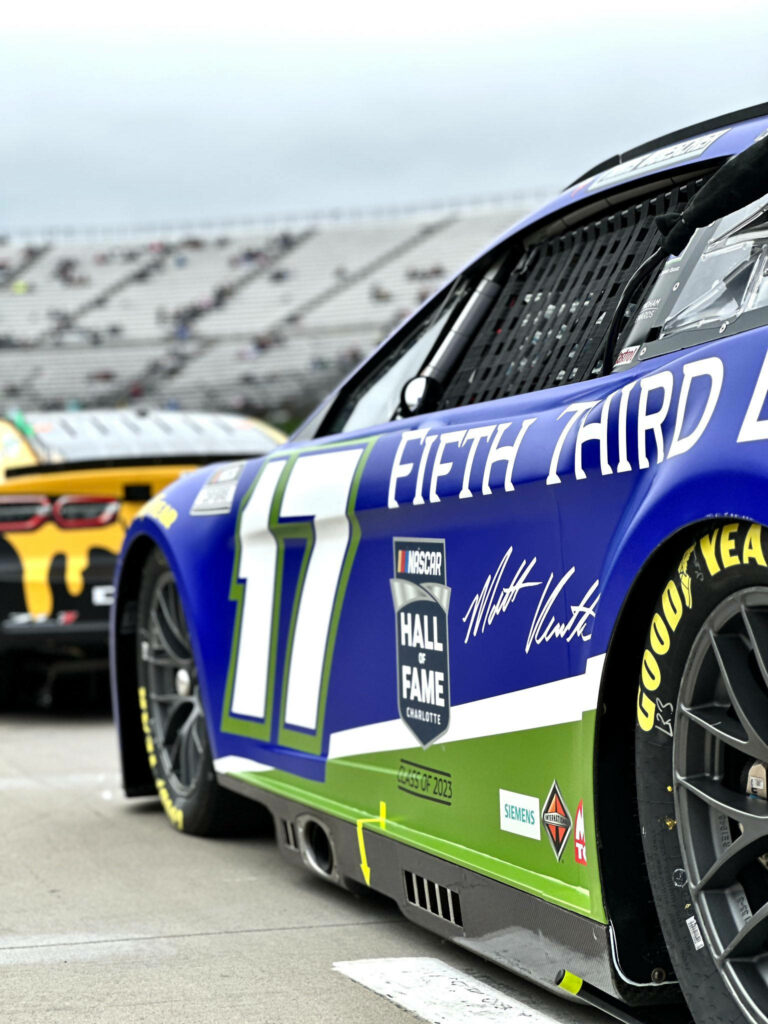 Close-up of Chris Buescher number 17 NASCAR race car detailed livery on track with grandstands Wallpaper