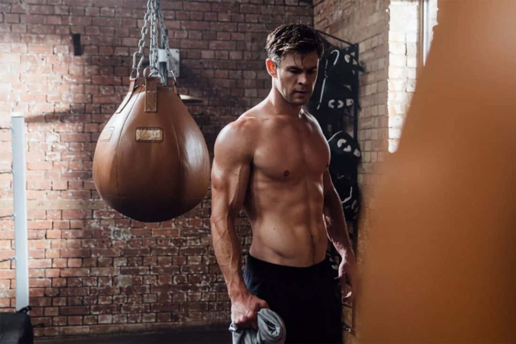 Chris Hemsworth shirtless muscular in rustic gym with leather punching bag fitness motivation wallpaper