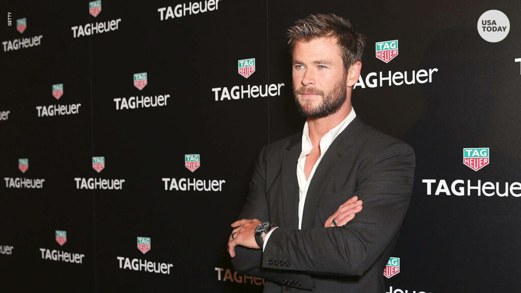 Chris Hemsworth in sharp suit on red carpet at TAG Heuer event stylish wallpaper background
