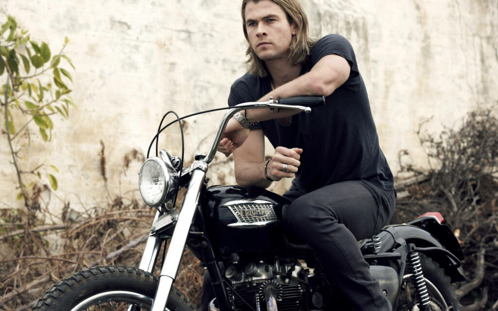 Chris Hemsworth confident on motorcycle outdoors stylish wallpaper cool adventurous vibe