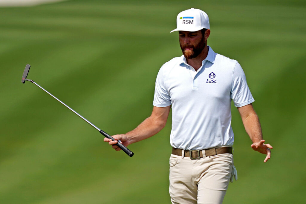 Chris Kirk focused on golf course holding putter wearing white polo khaki pants white cap Wallpaper