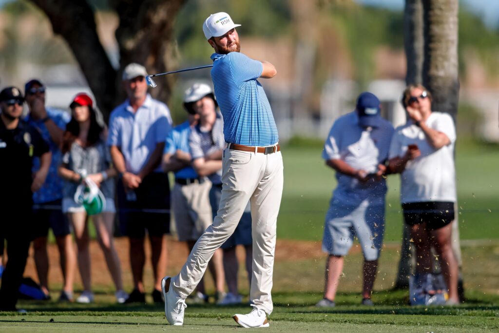 Chris Kirk mid-swing on sunny golf course with spectators and lush green background wallpaper