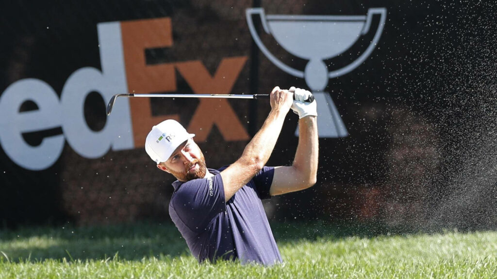 Chris Kirk mid-swing hitting sand trap with FedExCup backdrop vibrant green golf course wallpaper