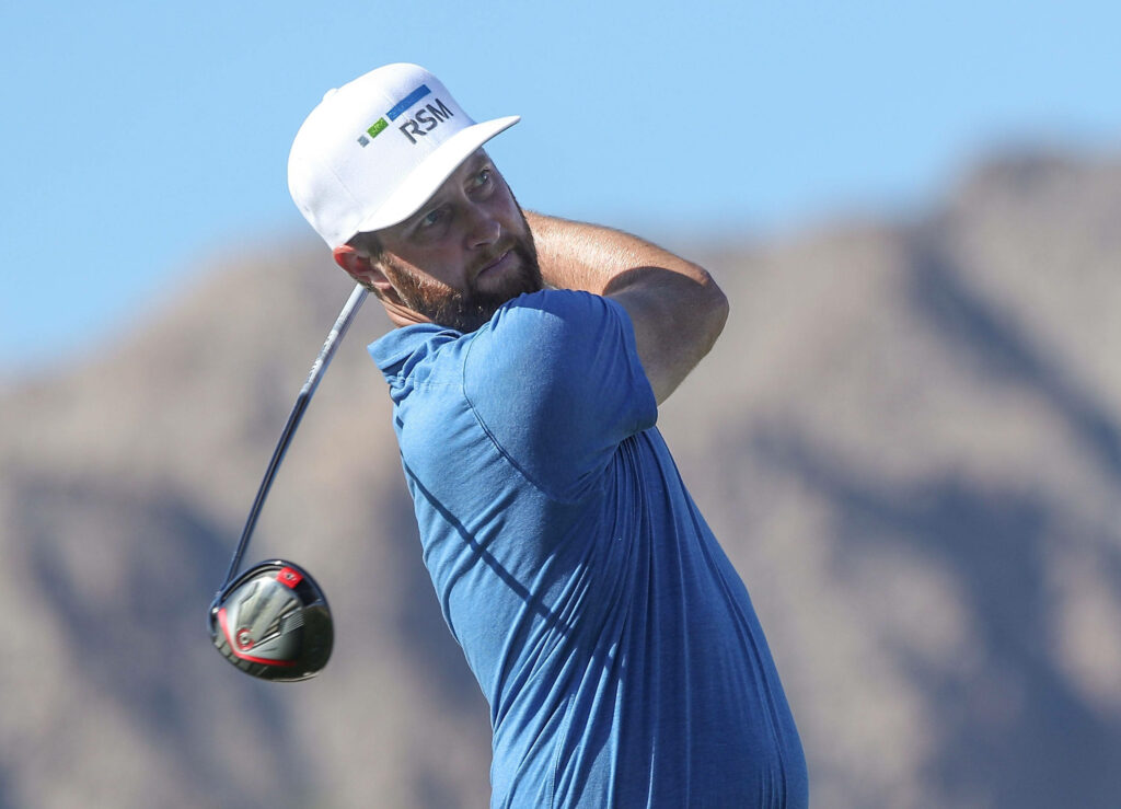 Chris Kirk professional golfer mid swing with mountain backdrop and blue shirt golf wallpaper background