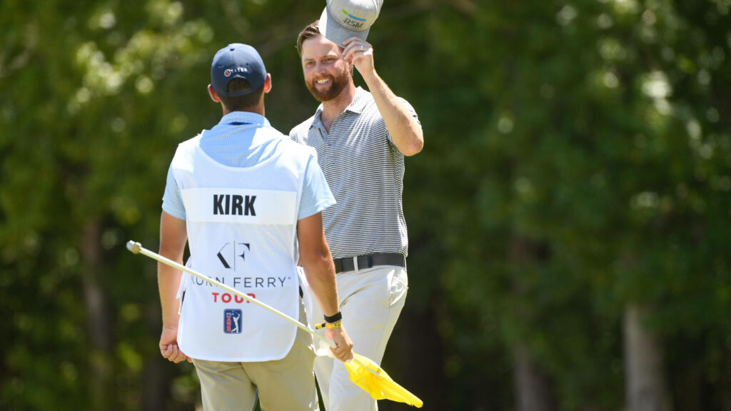 Professional golfer Chris Kirk smiling with his caddie on green golf course during tournament Wallpaper