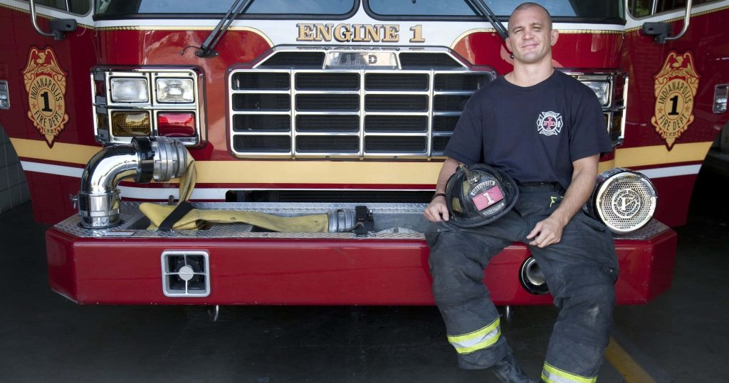 Chris Lytle former MMA fighter and Indianapolis firefighter in uniform holding helmet by Engine 1 Wallpaper