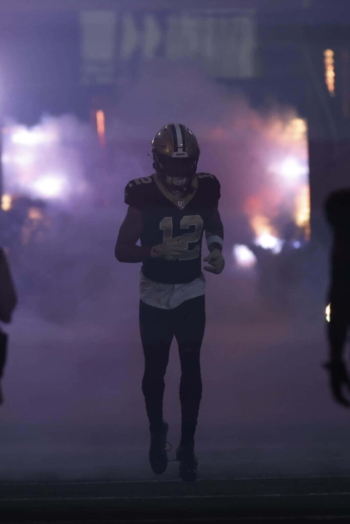 Chris Olave number 12 enters football field through dramatic smoke and lighting silhouette wallpaper