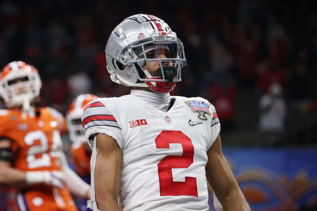Chris Olave Ohio State football jersey number 2 celebrating on field vibrant stadium wallpaper background