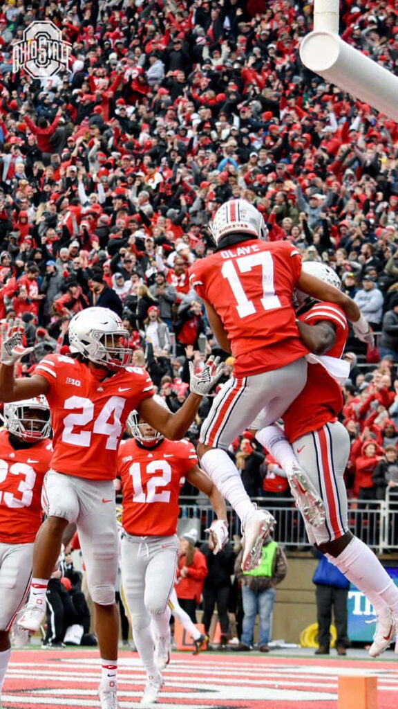 Chris Olave Ohio State touchdown celebration with teammates in packed stadium scarlet gray uniforms Wallpaper