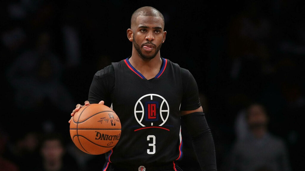 Chris Paul dribbling basketball in black LA Clippers jersey dark background intense game focus Wallpaper