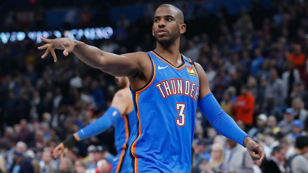 Chris Paul in Oklahoma City Thunder jersey extending arm in dynamic basketball game action Wallpaper