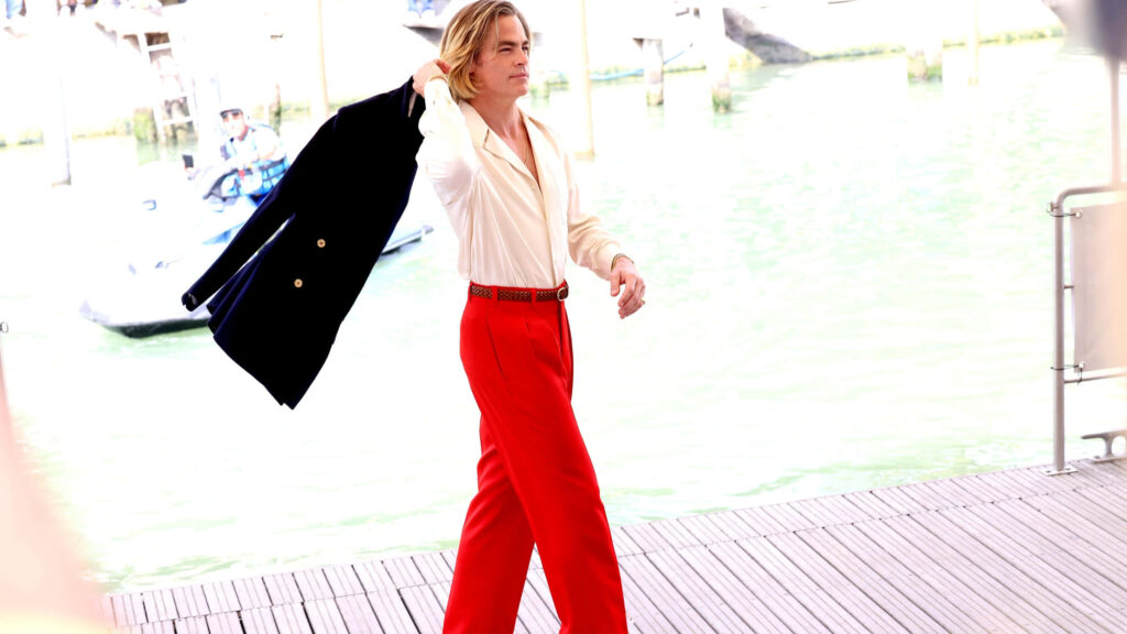 Chris Pine walking sunny waterfront cream shirt vibrant red pants dark jacket shoulder stylish wallpaper