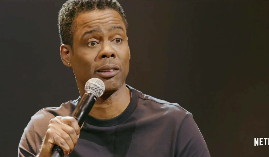 Chris Rock performing high-energy Netflix stand-up comedy with expressive humor wallpaper background