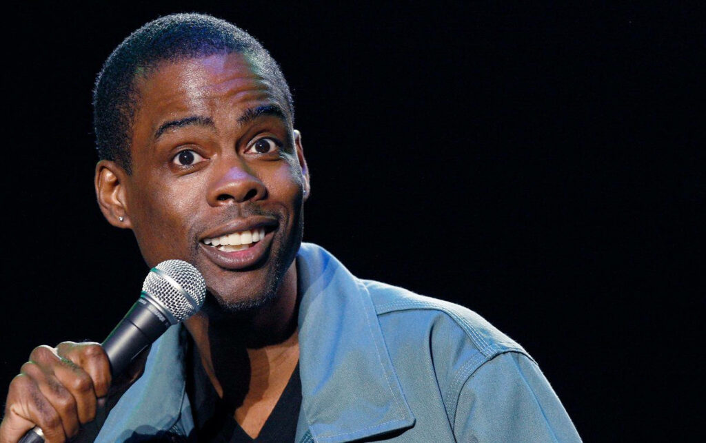 Chris Rock stand-up comedy wallpaper mid-performance holding microphone energetic expression