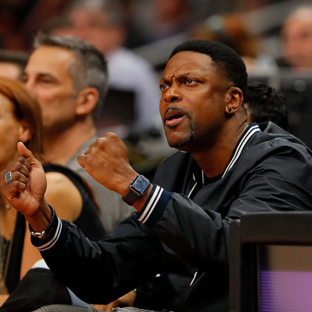 Chris Tucker courtside vibrant wallpaper energetic pose animated expression warm tones crowd