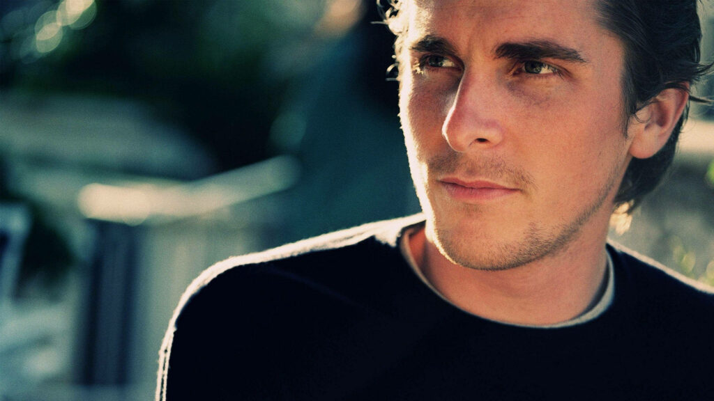 Christian Bale candid portrait wallpaper showing sharp features and thoughtful expression outdoors