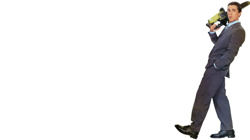 Christian Bale as Patrick Bateman in suit holding chainsaw intense stylish white background wallpaper