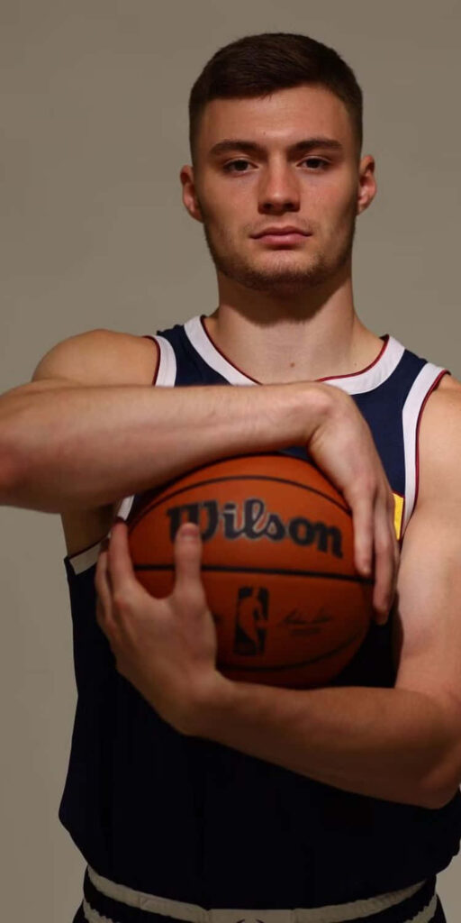 Christian Braun in basketball jersey holding Wilson NBA ball focused athletic portrait wallpaper
