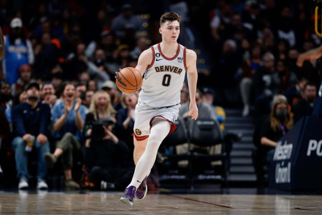 Christian Braun Denver basketball dribbling intense focus white gold uniform cheering fans Wallpaper