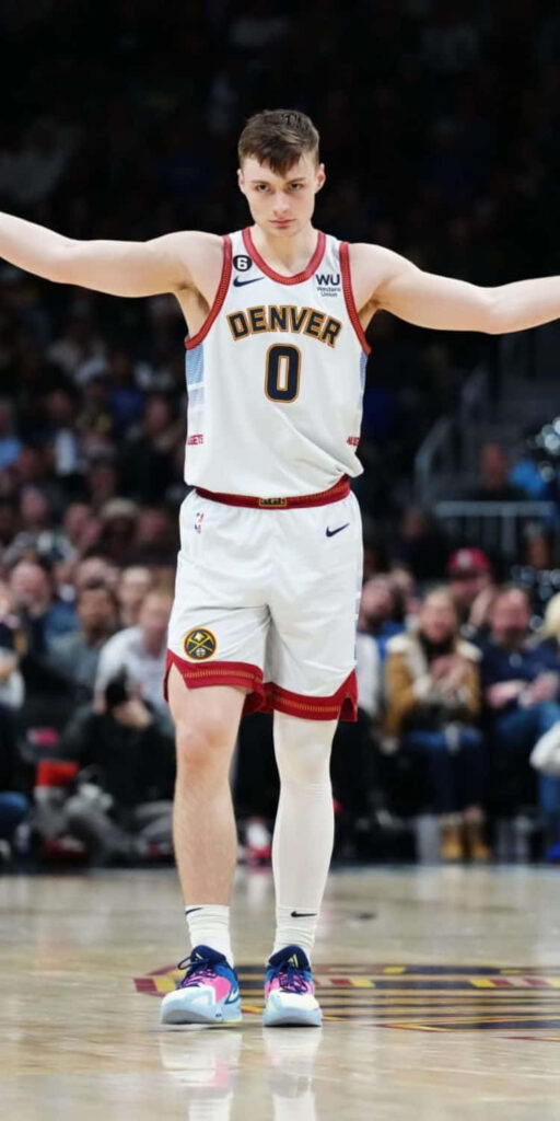 Christian Braun Denver basketball player celebrating victory in white jersey on vibrant court background Wallpaper