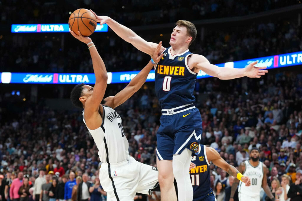 Christian Braun Denver Nuggets jersey 0 blocks shot during intense NBA game with vibrant crowd Wallpaper