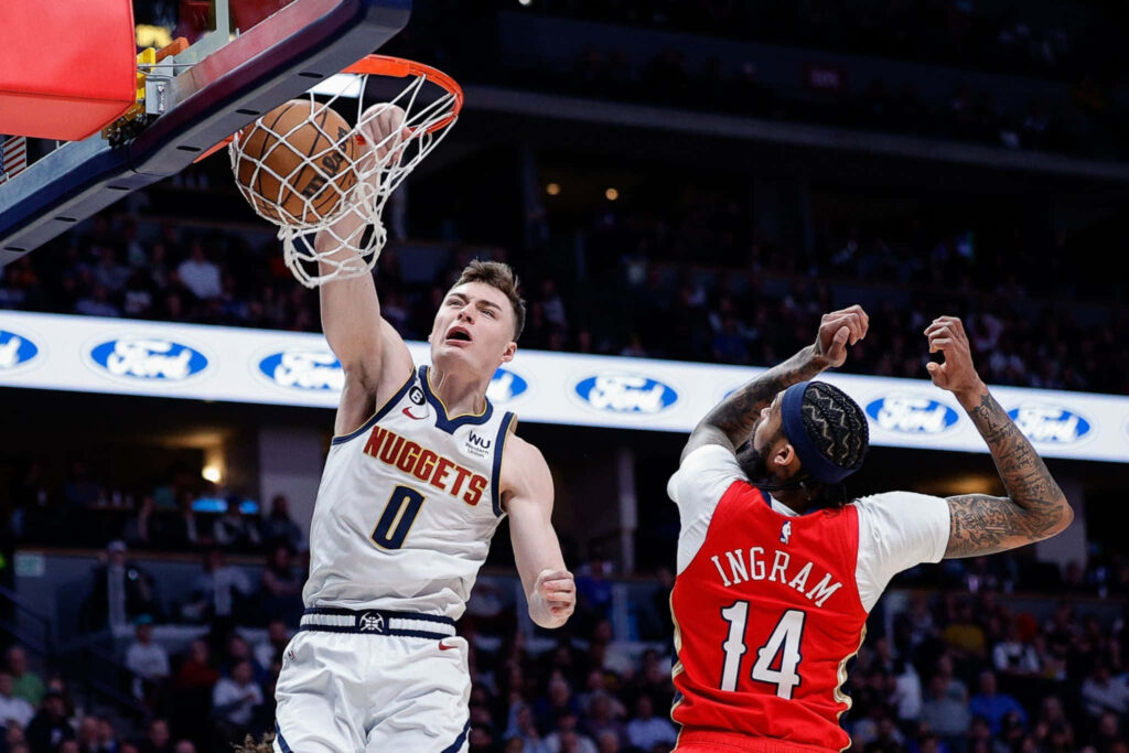 Christian Braun Denver Nuggets dunks over Brandon Ingram New Orleans Pelicans in intense NBA game Wallpaper