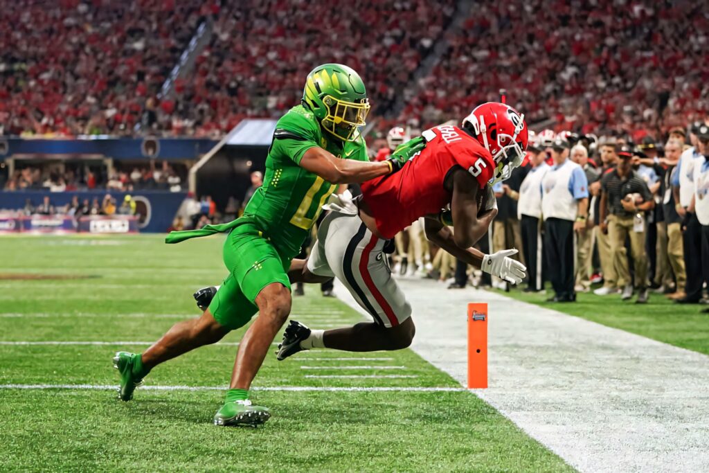 Christian Gonzalez football defensive play near end zone vibrant green uniform college football action Wallpaper