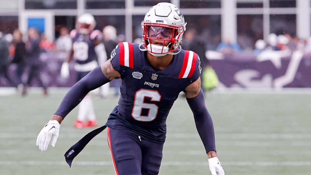 Christian Gonzalez in New England Patriots uniform focused on football field action game day energy Wallpaper