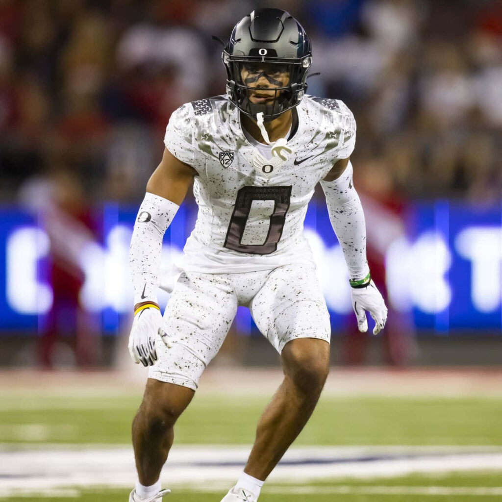 Christian Gonzalez in Oregon Ducks white football uniform in action on vibrant stadium field wallpaper