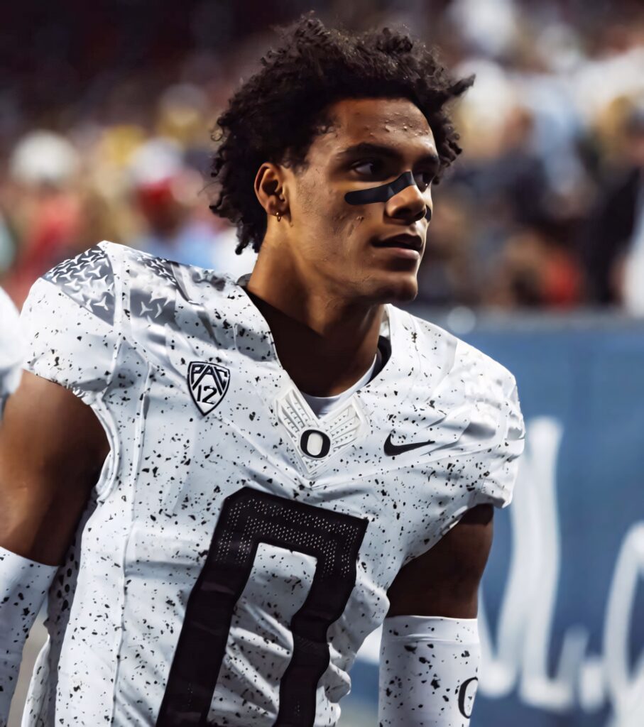 Christian Gonzalez in Oregon Ducks football uniform with black white splatter pattern on field Wallpaper