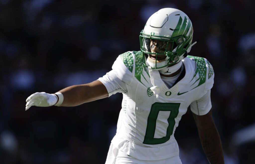 Christian Gonzalez Oregon Ducks football player in action high energy stadium background wallpaper