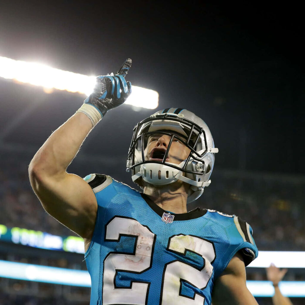 Christian McCaffrey running back in Carolina Panthers blue and black uniform celebrating on field Wallpaper