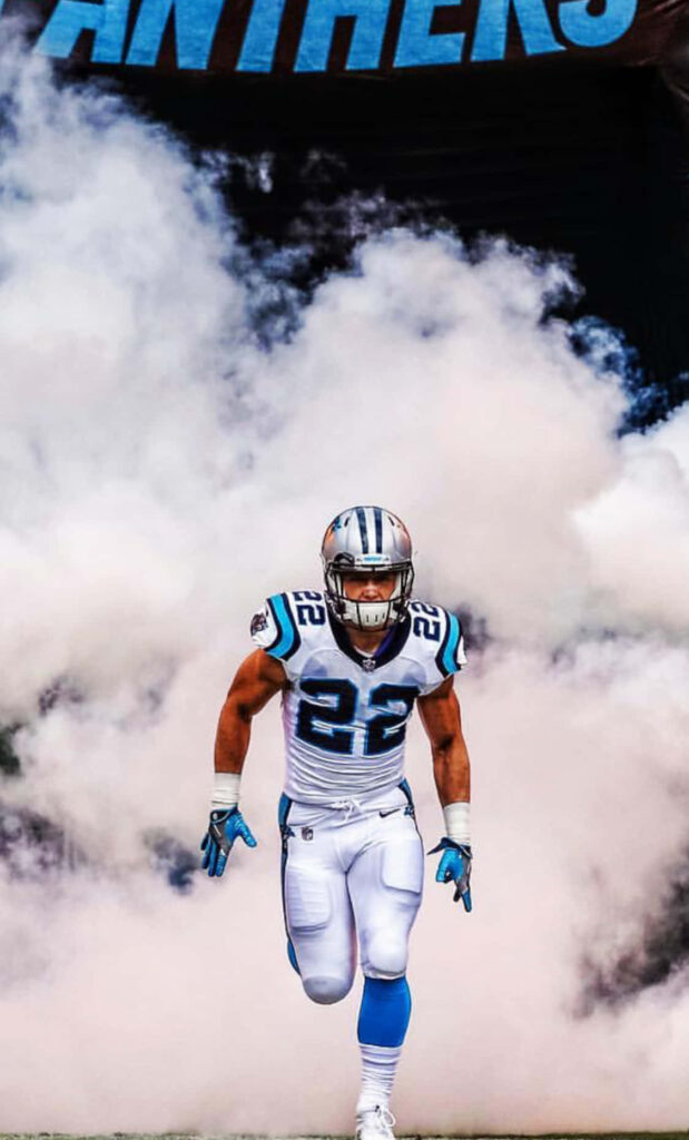 Christian McCaffrey Carolina Panthers running back bursts through smoke in blue black white uniform Wallpaper