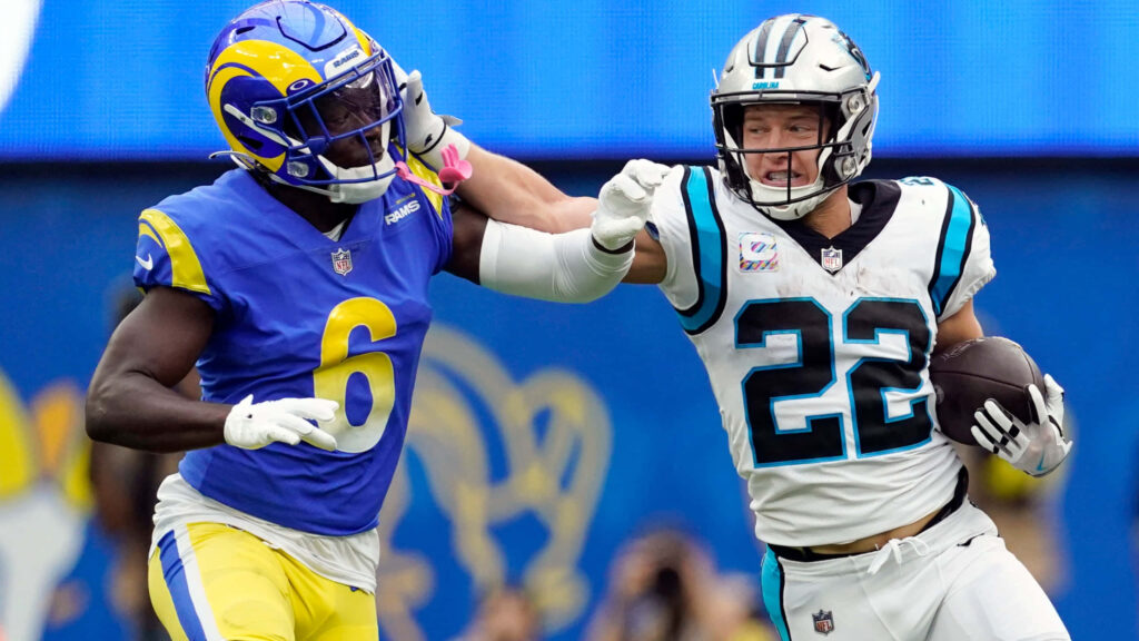 Christian McCaffrey stiff-arm against Derion Kendrick NFL Panthers vs Rams action wallpaper