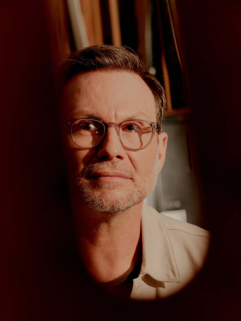Christian Slater portrait wallpaper with warm lighting thoughtful expression stylish eyeglasses