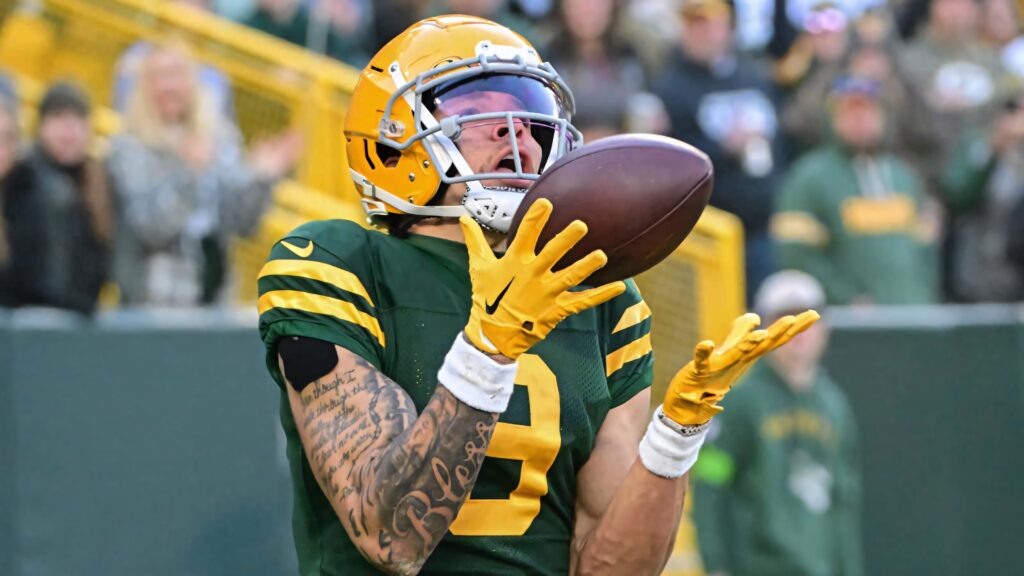 Christian Watson Green Bay Packers catching football mid-action in stadium with green gold colors Wallpaper
