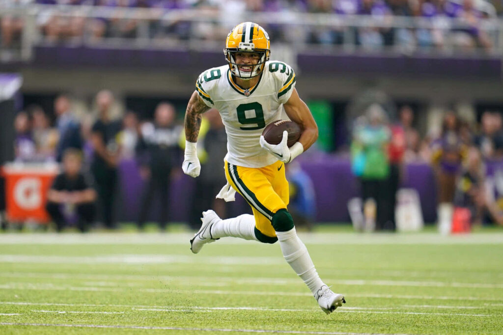 Christian Watson Green Bay Packers wide receiver sprinting in green and yellow uniform NFL action Wallpaper