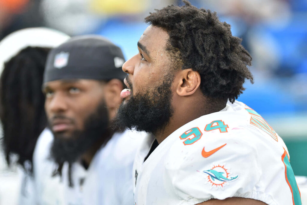 Christian Wilkins focused on Miami Dolphins sideline vibrant uniform natural light football wallpaper