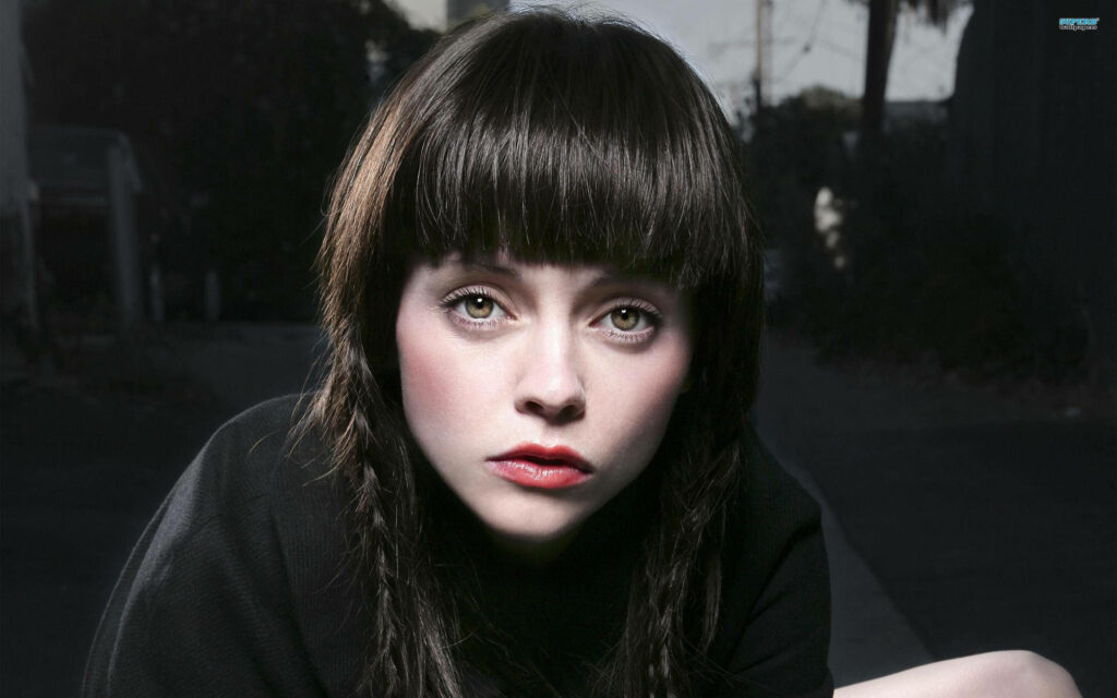Christina Ricci with full bangs dark braided hair moody outdoor wallpaper background portrait