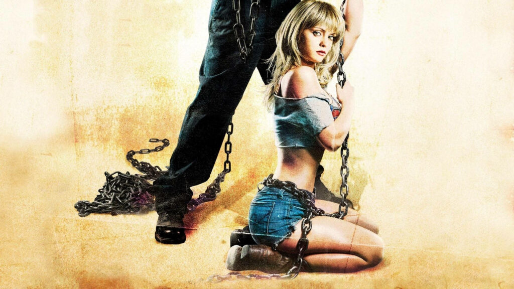 Christina Ricci kneeling in torn denim shorts crop top with chains textured wallpaper background