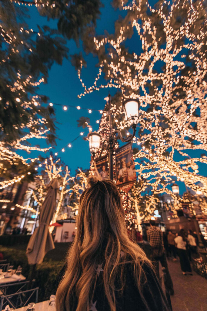 Enchanting Christmas Evening: Twinkling Lights & Cozy Lanterns Wallpaper